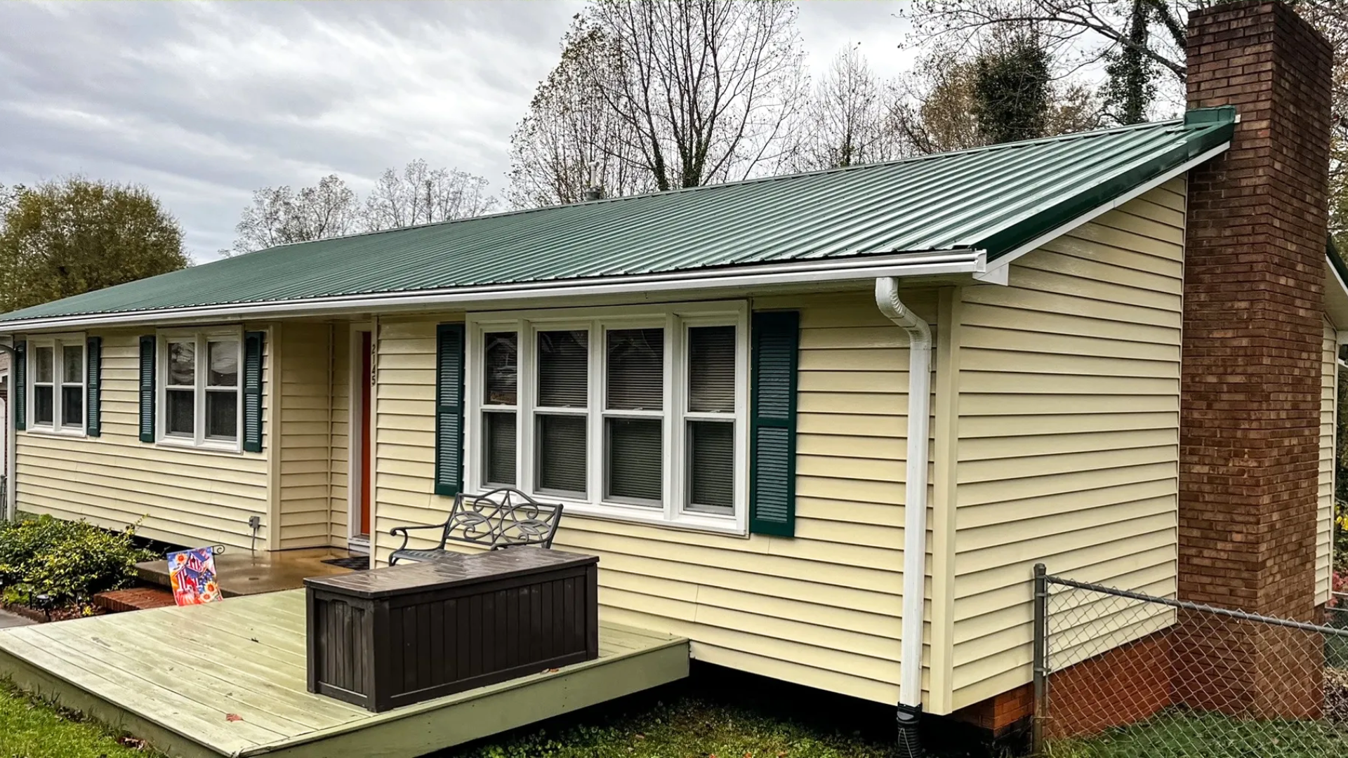 Washed ranch home with green metal roof