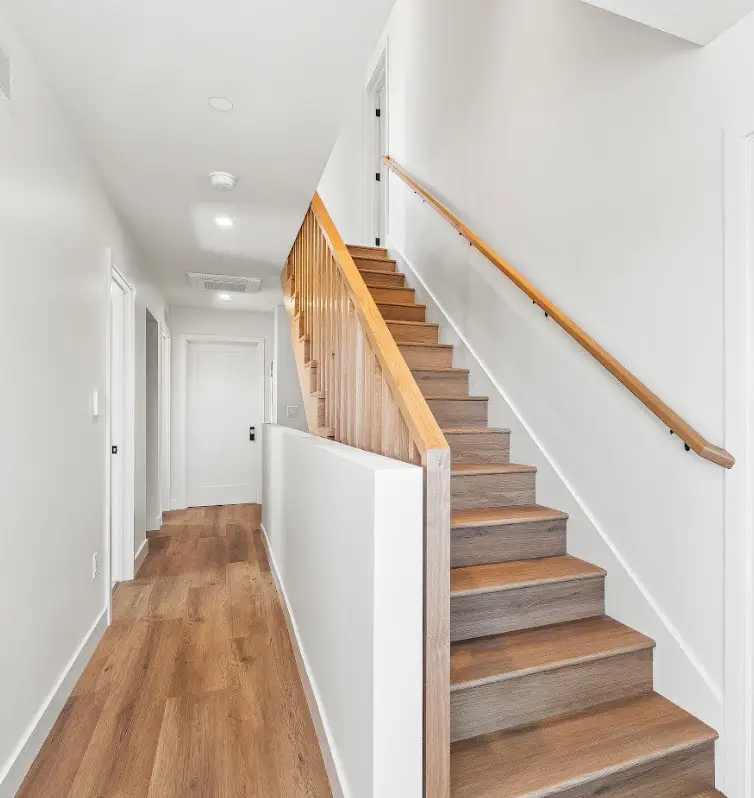 New wood-look flooring installed in a bright hallway and staircase